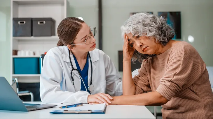 Uma médica antendendo uma senhora que está triste