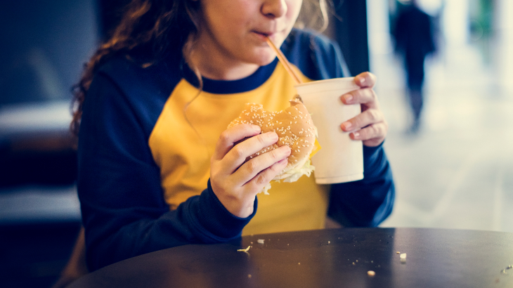 Menina comendo fast food