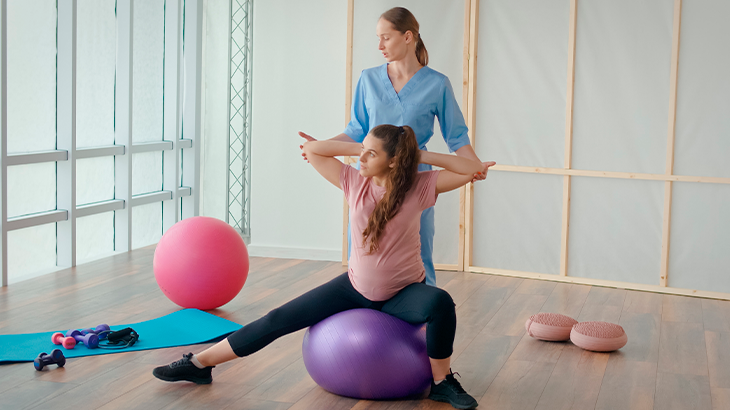 Mulher sentada em cima da bola de pilates fazendo exercício