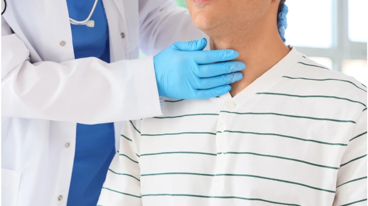 Médico com a mão no pescoço do paciente