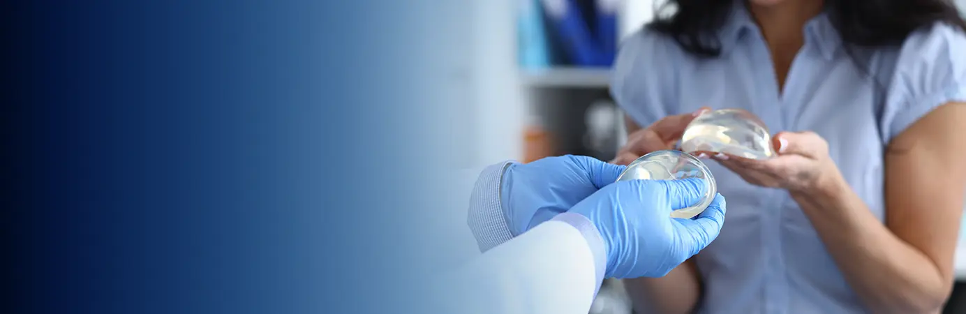 Médico e paciente com uma prótese mamária nas mãos.